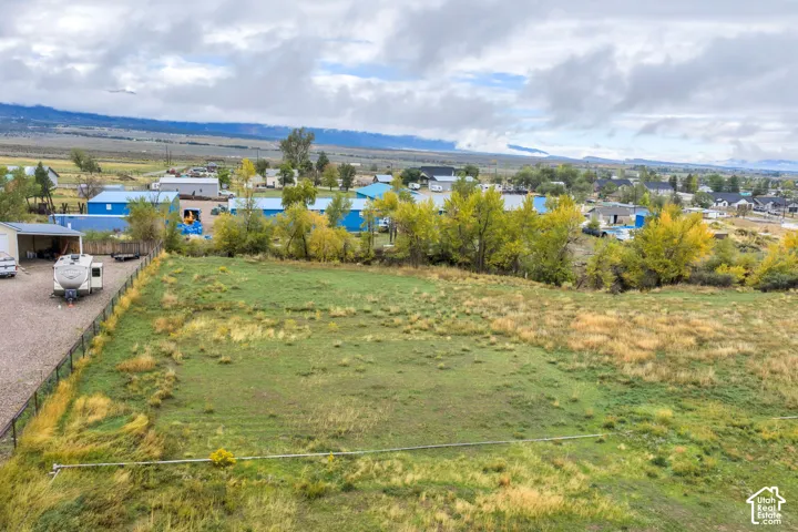 Expansive parcel with perimeter fencing, gravel access, and mature trees
