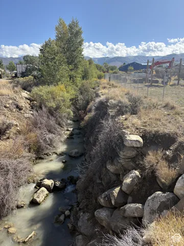 Natural stream running through the property, bordered by rock formations and mature trees