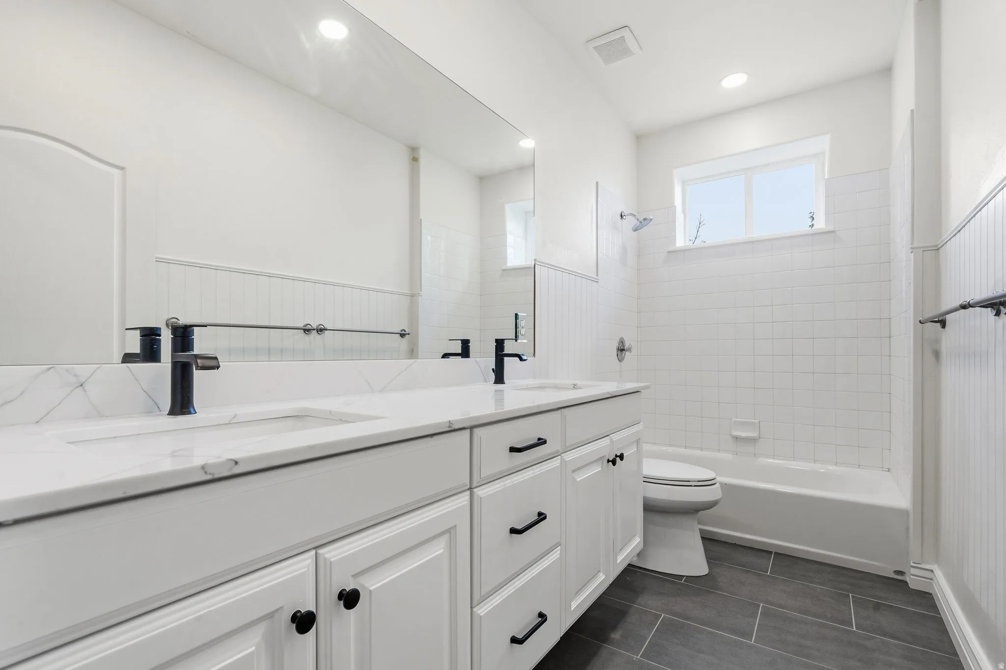 Dual sink vanity with white cabinetry and black hardware