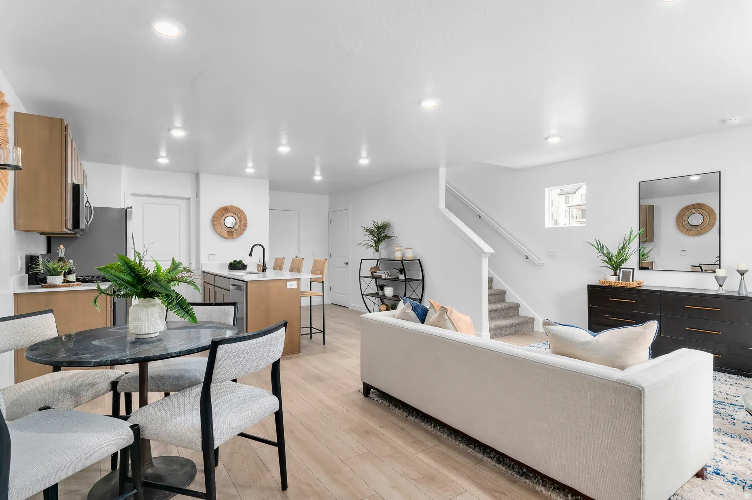 Open-concept living space featuring wood-finish flooring, recessed lighting, and a neutral color palette
