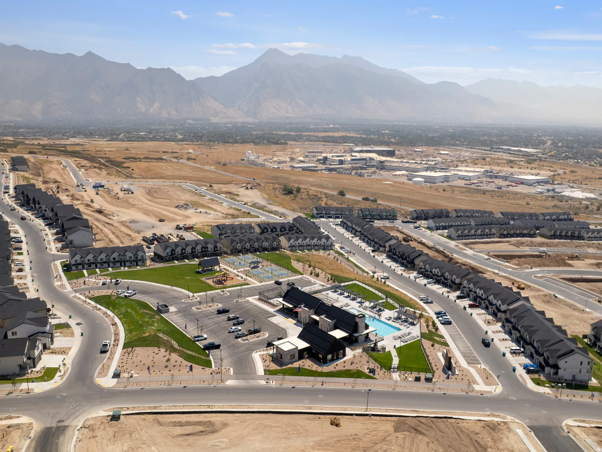 Community with townhomes, a central parking area, and a swimming pool