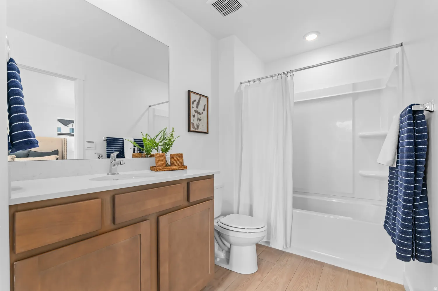 Modern vanity with wood-finish cabinetry, white countertop, and integrated sink