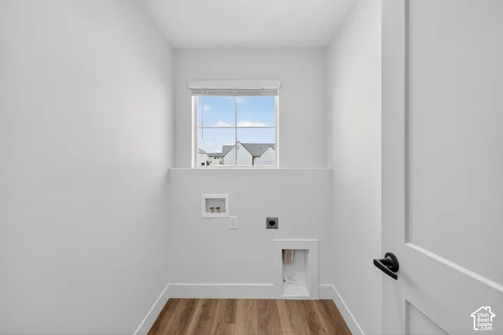Compact utility space featuring wood-finish flooring, a single window, and white walls