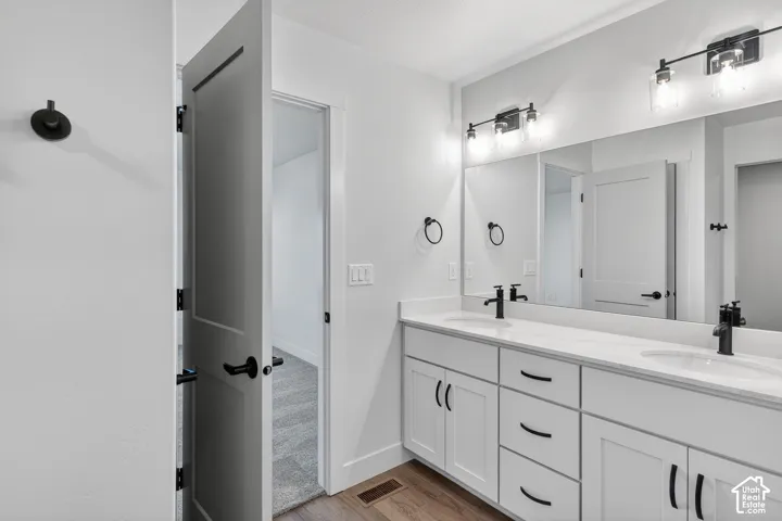 Double vanity with white cabinetry and matte black hardware