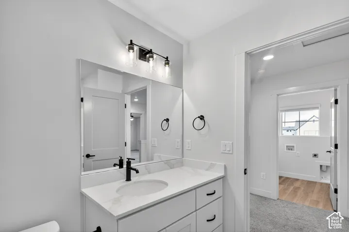 White vanity with a built-in sink and countertop, framed by a rectangular mirror