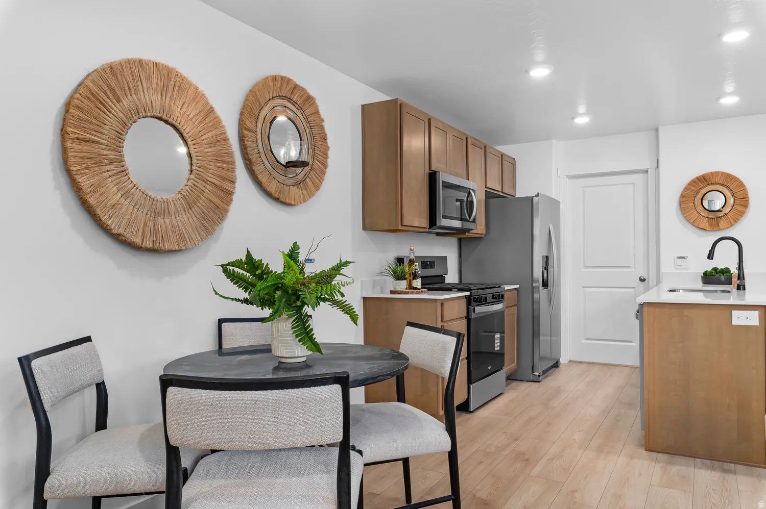 Well-appointed kitchen featuring wood-finish flooring, recessed lighting, wood cabinetry, stainless steel appliances, and solid surface countertops