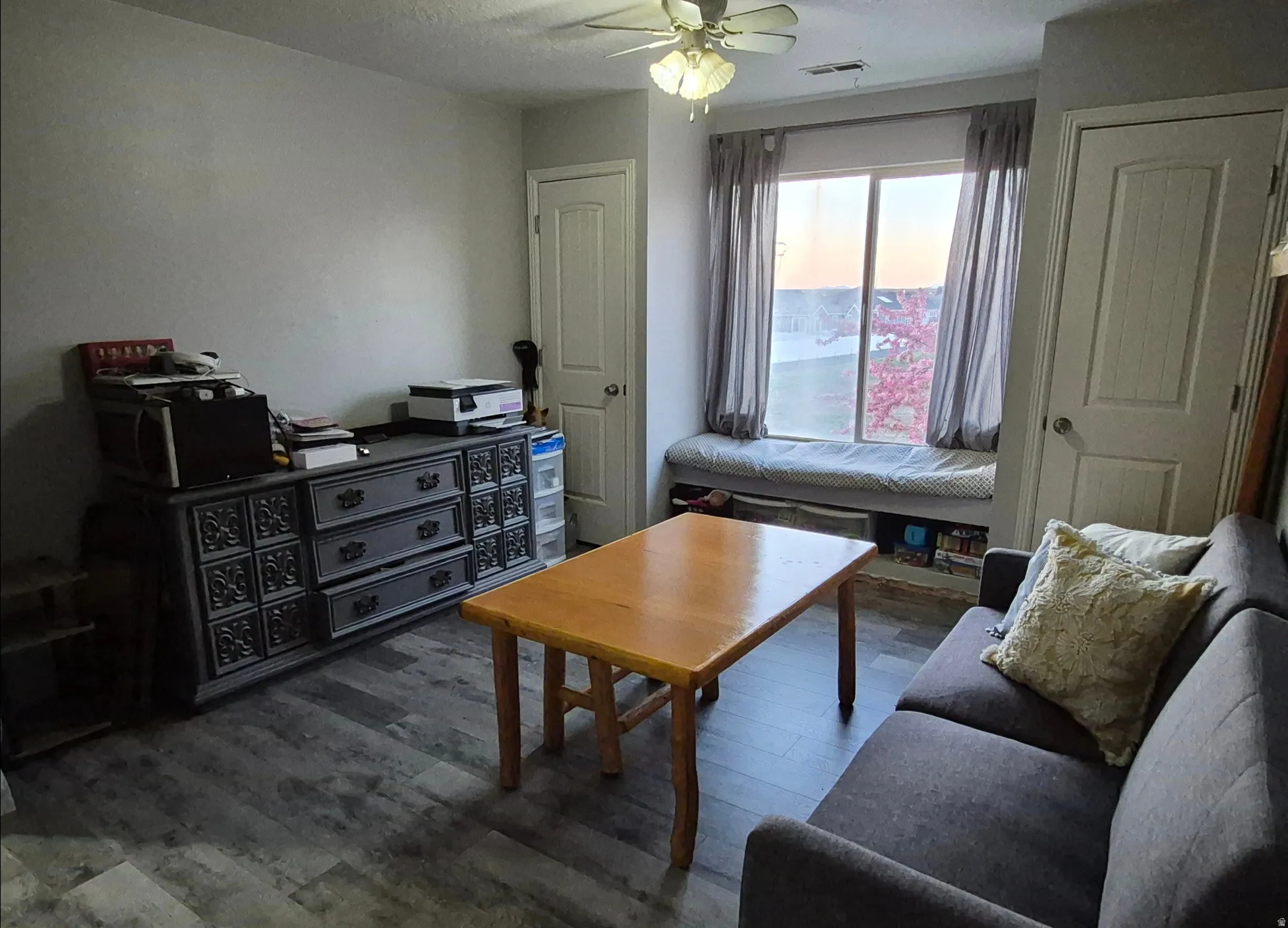 Wood-finish flooring, ceiling fan, built-in window seat, and paneled doors