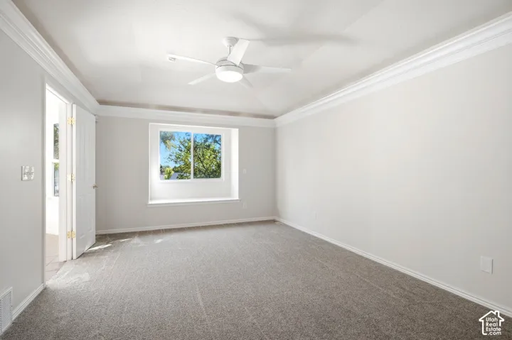 Crown molding, recessed window with a deep sill, ceiling fan with integrated lighting, wall-to-wall carpeting, and double-door entry