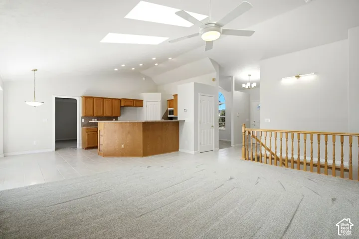 Vaulted ceilings with skylights, recessed lighting, and a ceiling fan