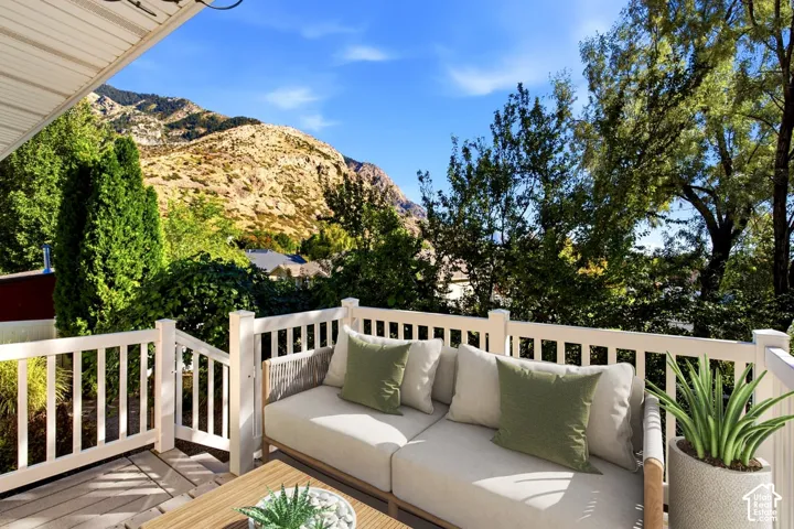 Expansive outdoor deck with a white railing system, offering mountain and tree scenery