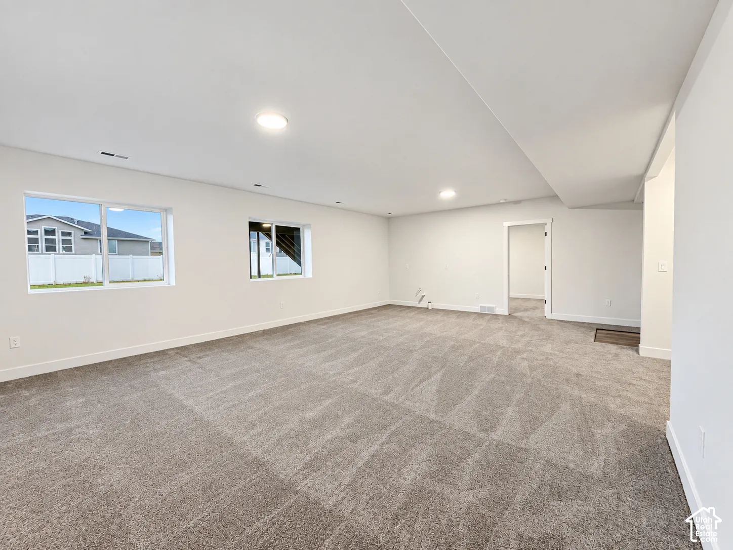 Spacious room with gray carpet flooring and white walls