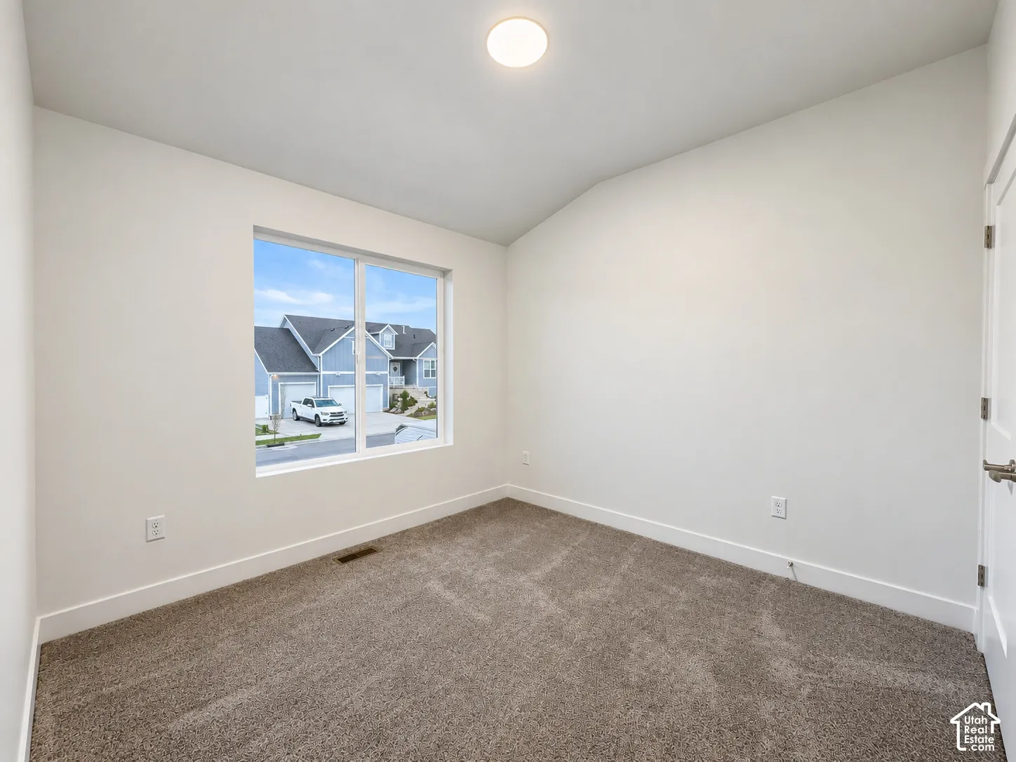 Carpeted flooring, white walls, and a single window