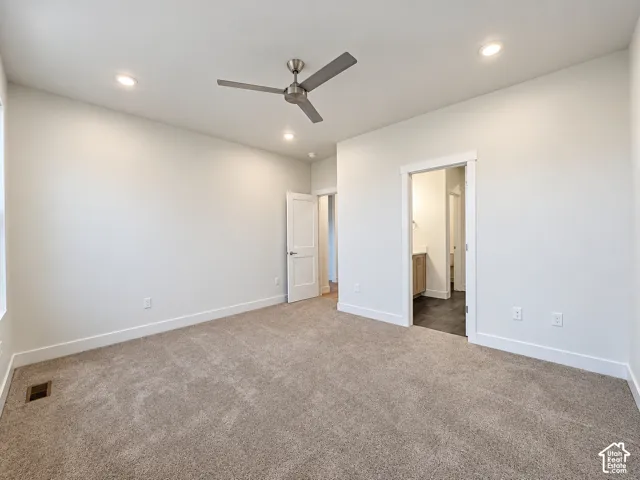 Spacious primary bedroom with neutral wall finishes, recessed lighting, and ceiling fan