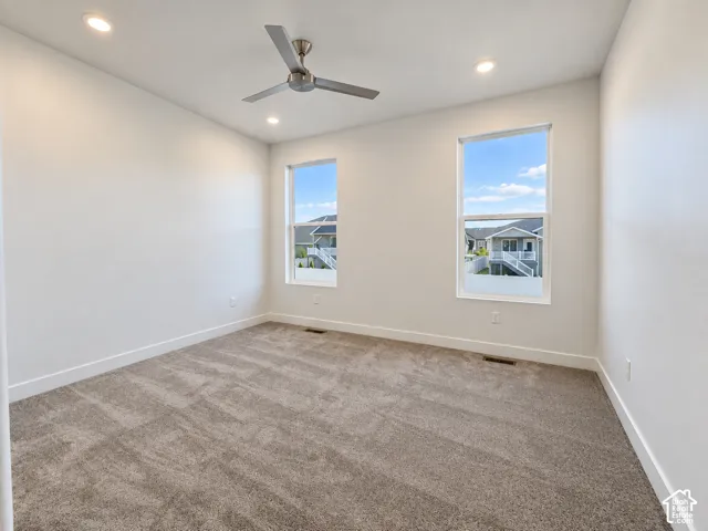 Wall-to-wall carpeting, dual recessed ceiling lights, and a ceiling fan with integrated lighting