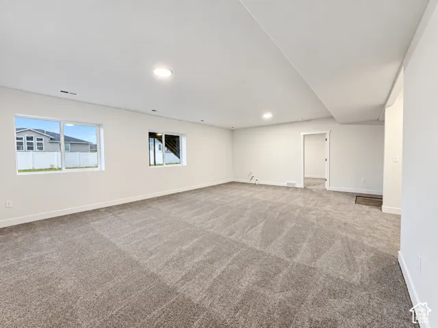 Spacious room with gray carpet flooring and white walls