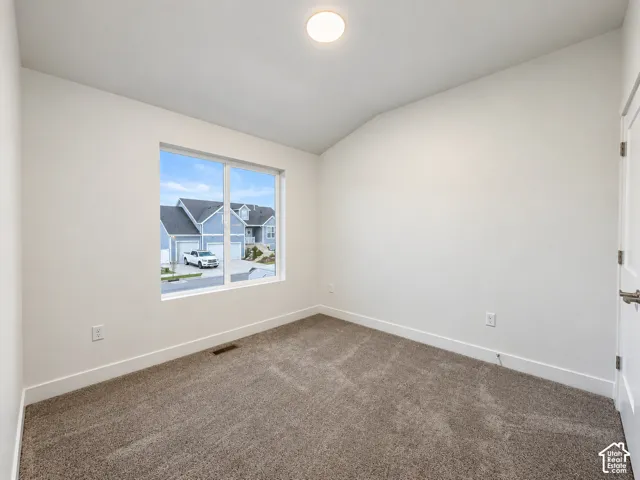 Carpeted flooring, white walls, and a single window
