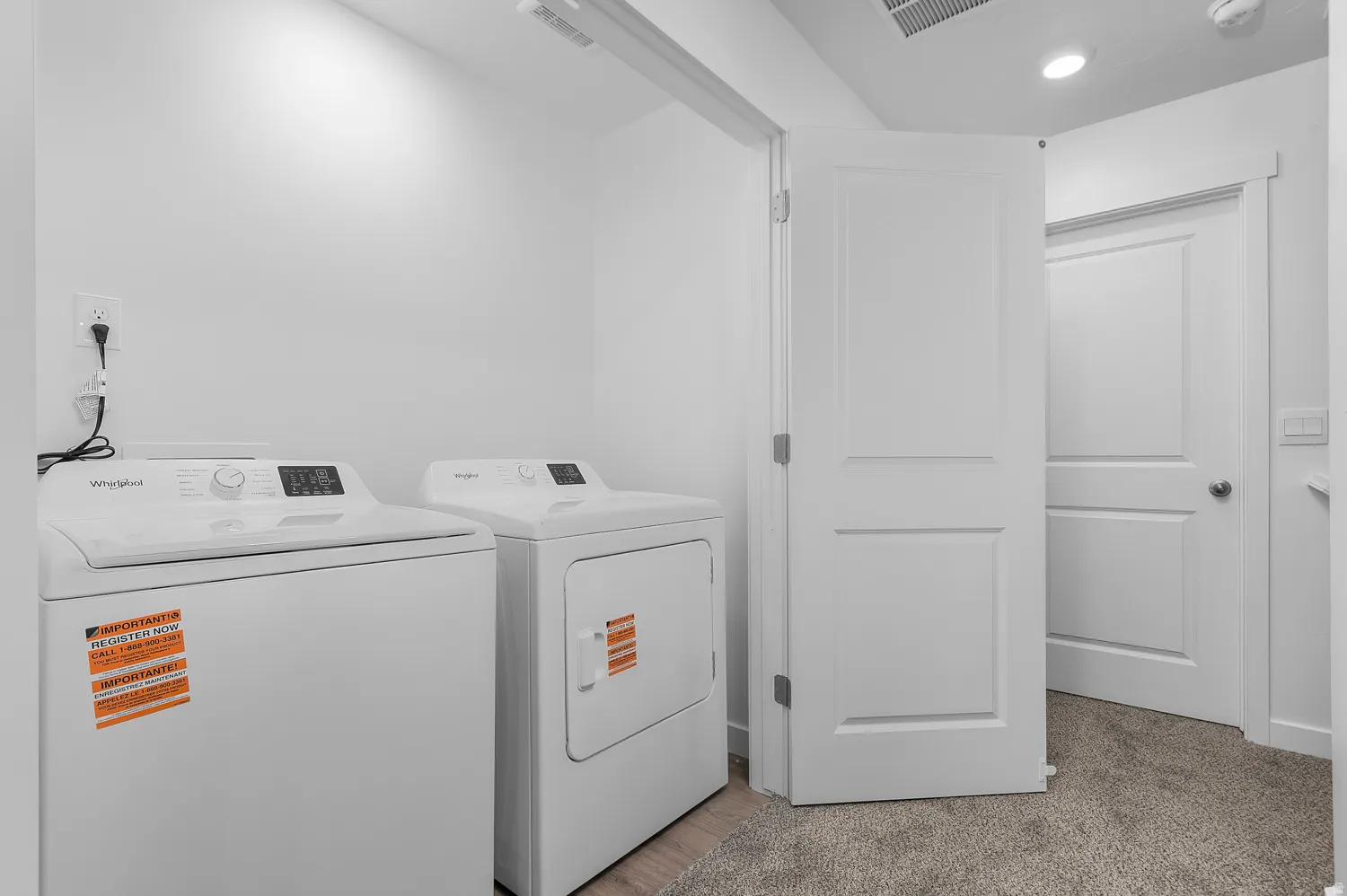 Dedicated laundry area featuring a washer and dryer, recessed lighting, and a neutral color palette