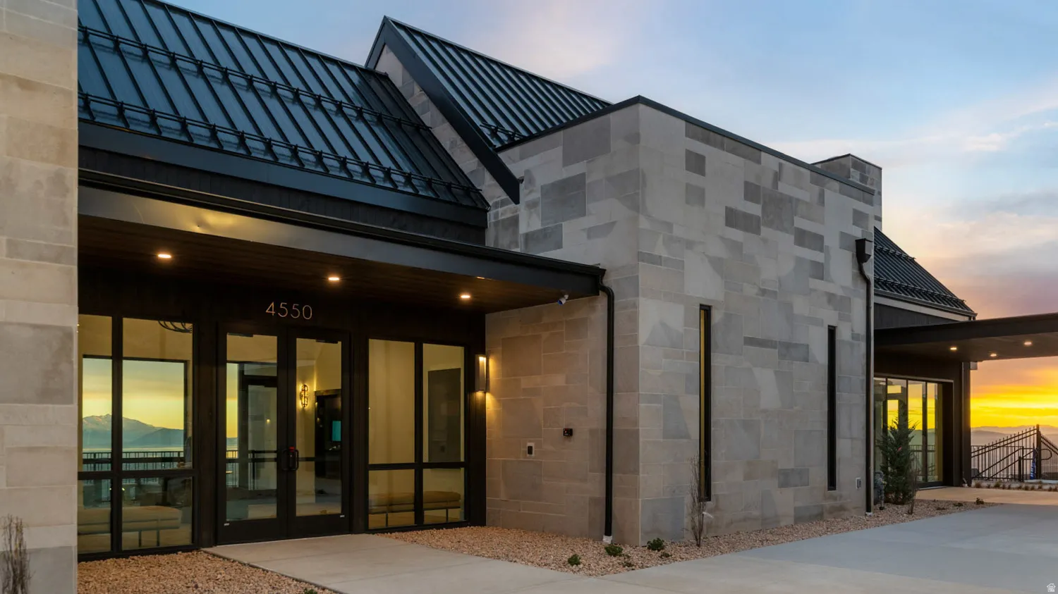 Stone cladding exterior with a black standing seam metal roof
