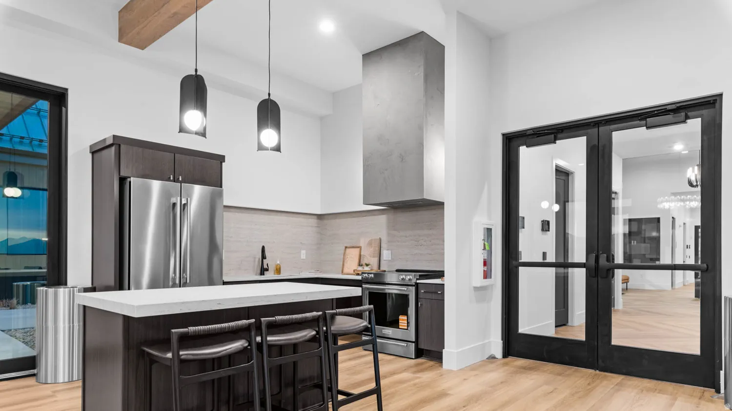 Modern kitchen featuring a stainless steel refrigerator, dark wood-finish cabinetry, light-colored countertops, and a full-height tile backsplash