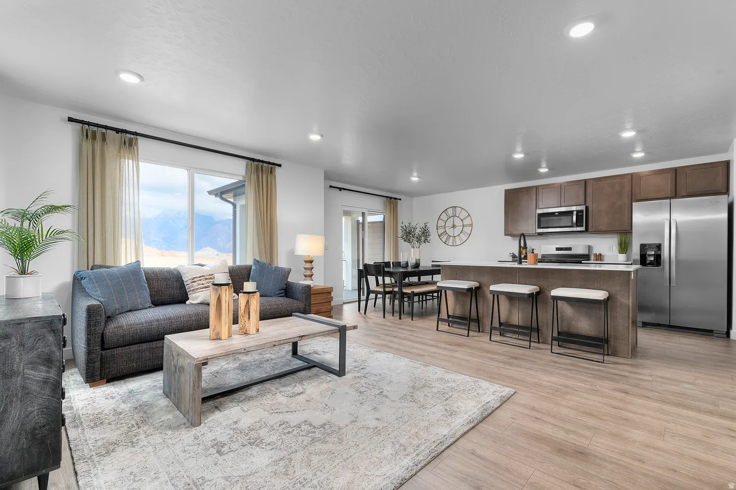 Open-concept living space with wood-finish flooring, recessed lighting, and a sliding glass door