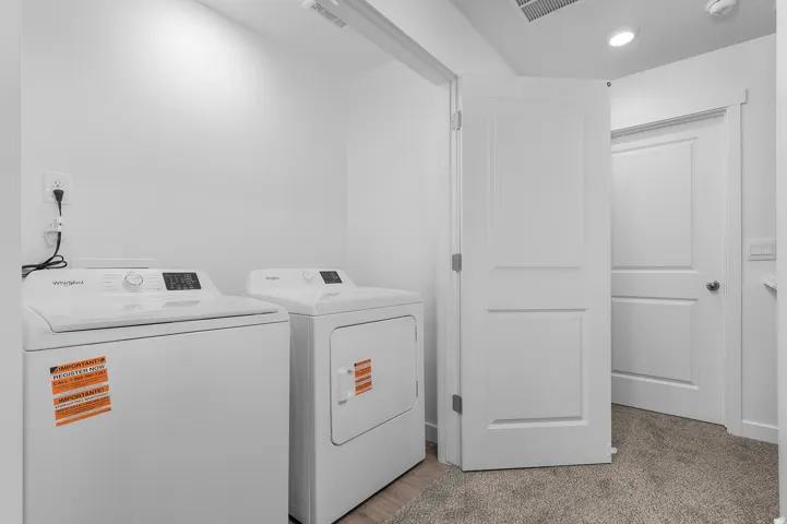 Dedicated laundry area featuring a washer and dryer, recessed lighting, and a neutral color palette