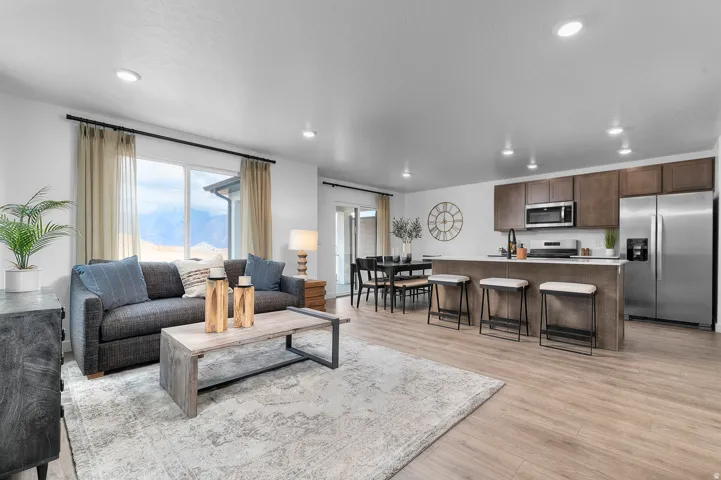 Open-concept living space with wood-finish flooring, recessed lighting, and a sliding glass door