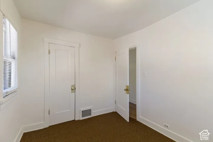 White paneled interior doors with brass hardware, white trim, and a window with blinds