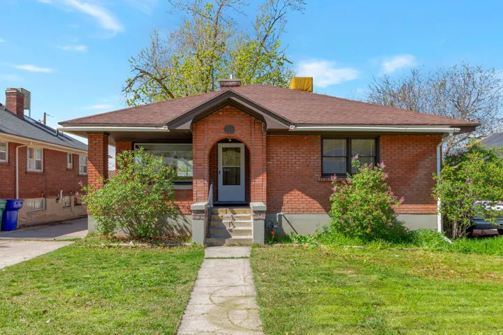 Brick exterior with a gabled roof and arched entry