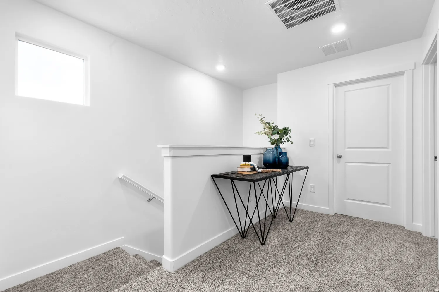 White interior walls, recessed lighting, white trim, white panel doors, and grey carpet flooring