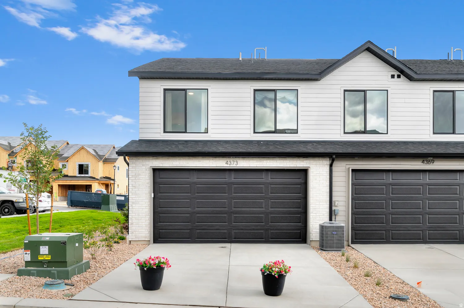 Modern exterior with white horizontal siding and dark gray garage doors