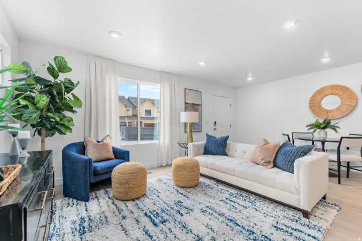Recessed lighting, light wood-finish flooring, white walls, and a large window with white blinds
