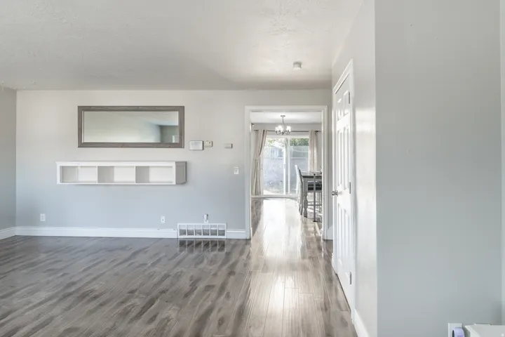 Wood-finish flooring, light gray wall paint, and white trim accents