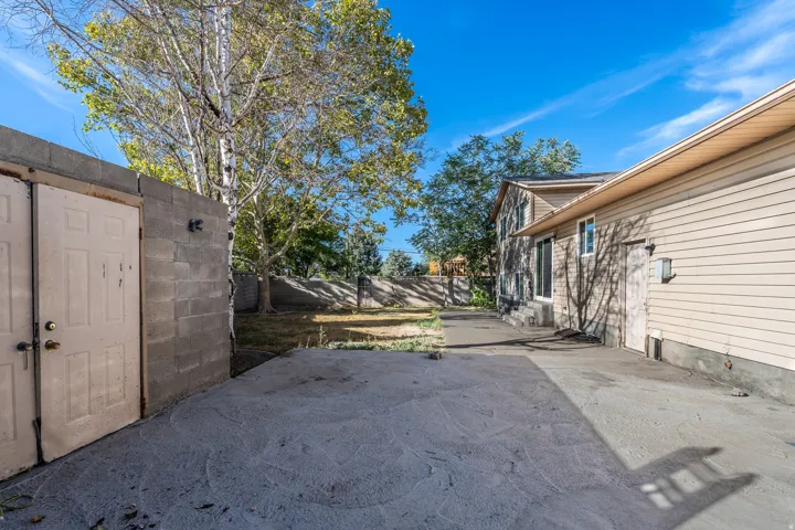 Concrete patio with perimeter block wall and mature trees