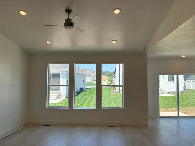 Recessed lighting, ceiling fan, wood-finish flooring, multiple windows, sliding glass door