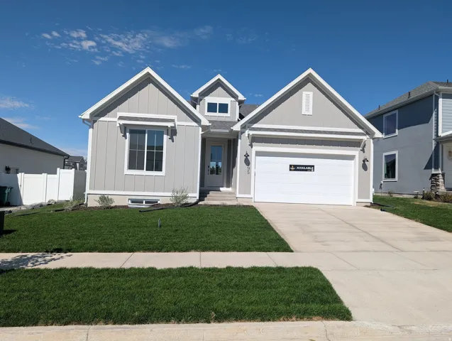 Single-story residence featuring light gray siding, white trim accents, a two-car garage, and a concrete driveway