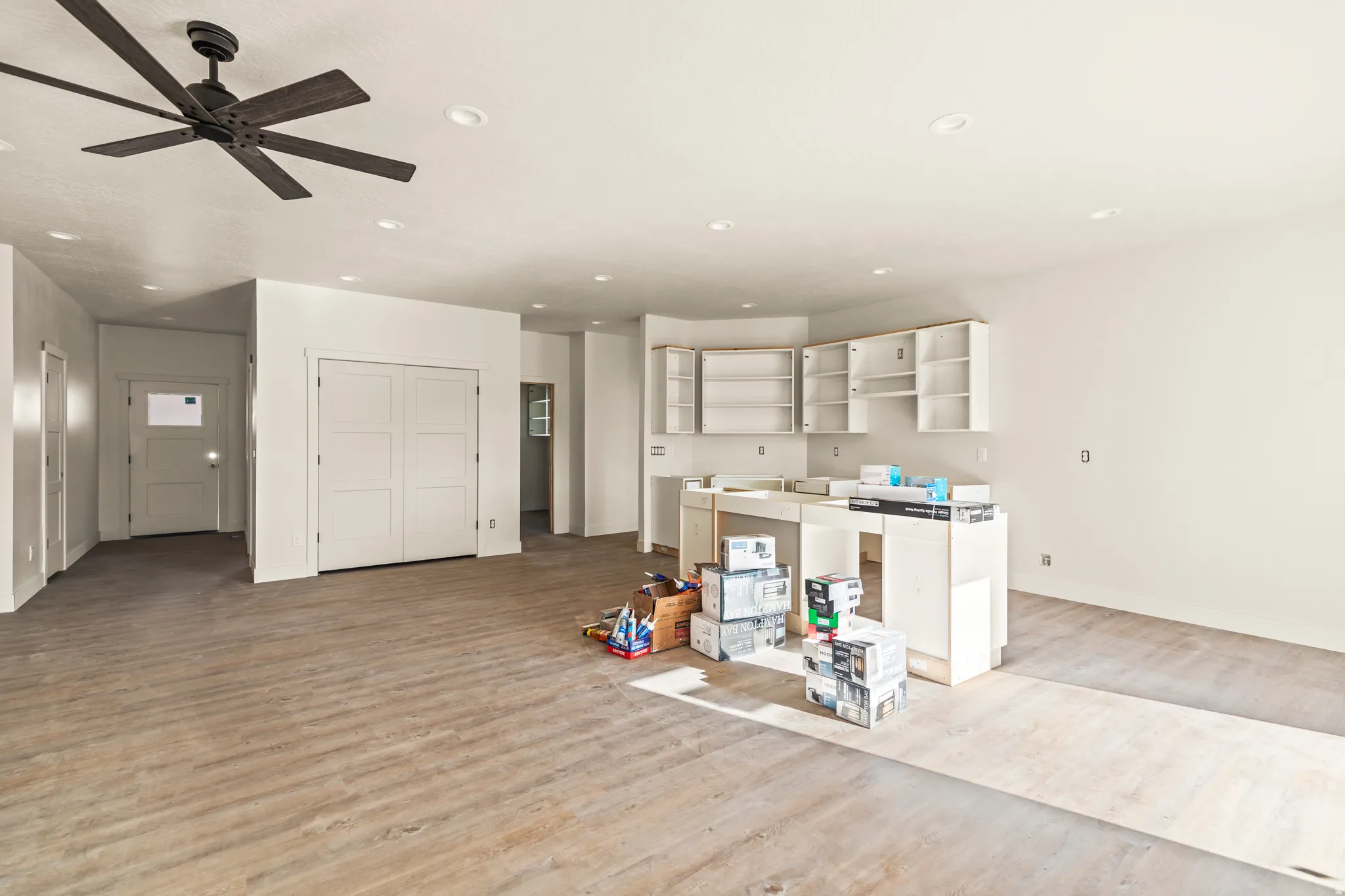 Spacious interior with wood-finish flooring, recessed ceiling lighting, and a modern ceiling fan