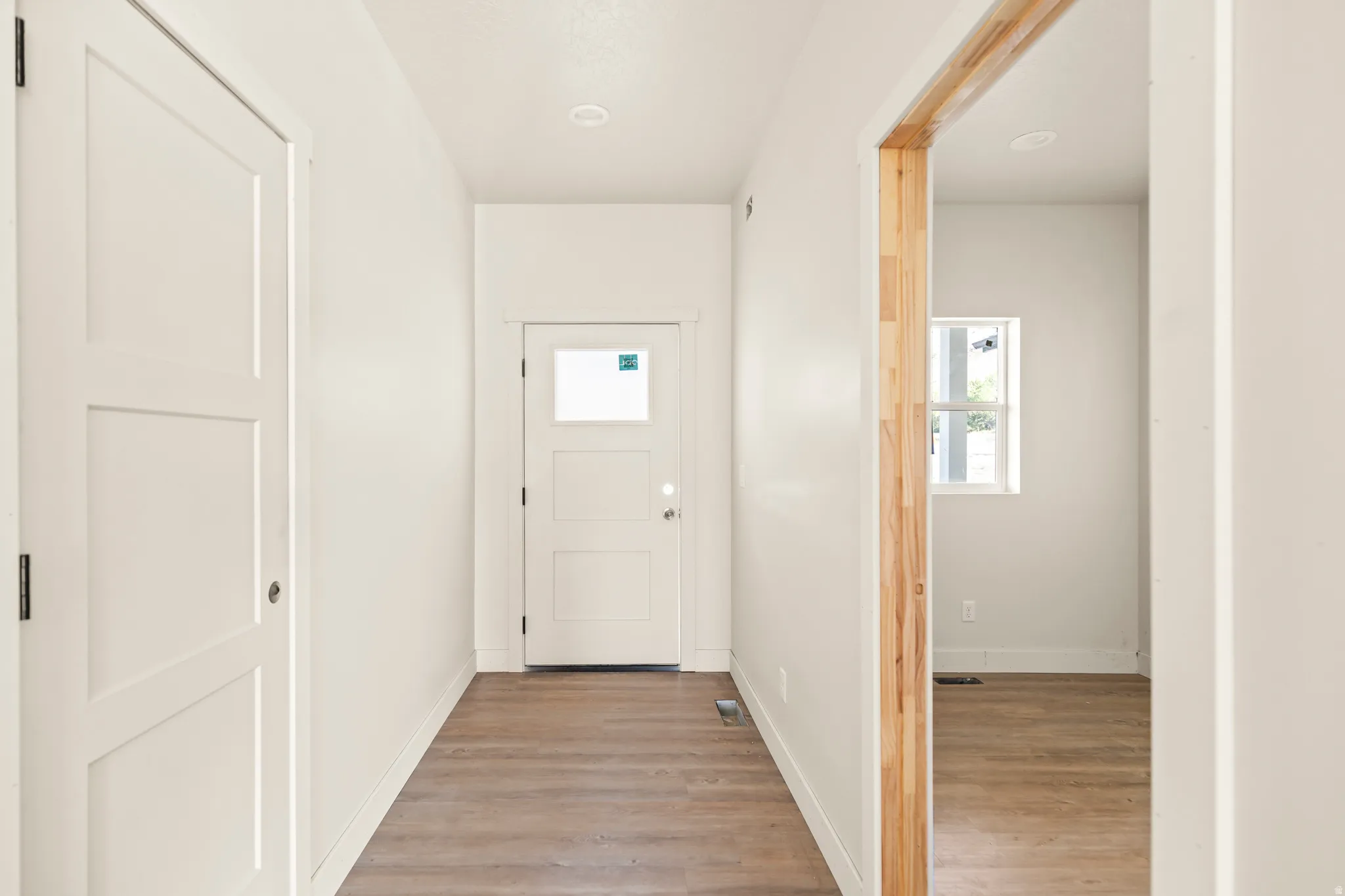 Wood-finish flooring throughout, bright white walls, and recessed lighting