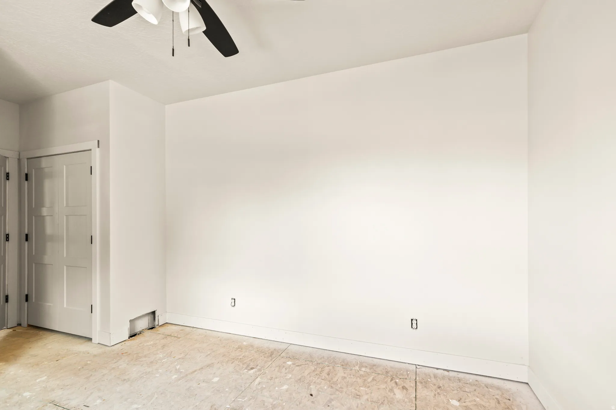 Ceiling fan with multiple light fixtures, panel door, and neutral wall tones