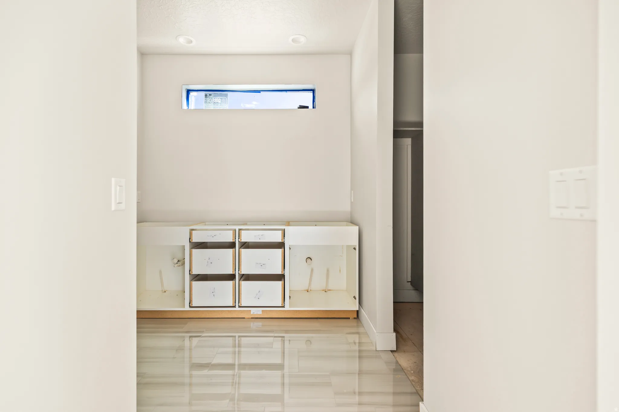 Recessed lighting, base cabinetry, transom window, and tile flooring