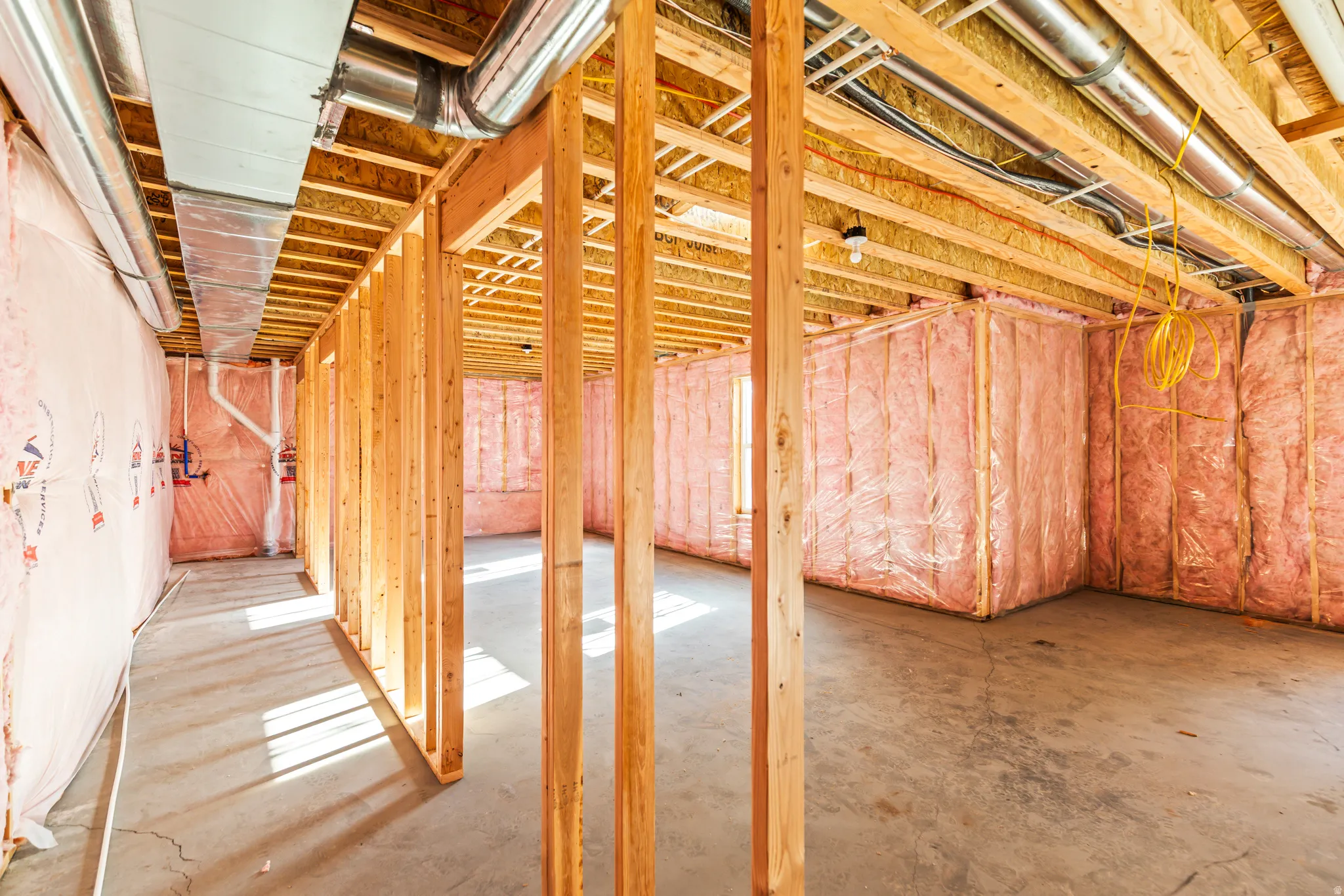 Unfinished basement with concrete flooring and exposed wood framing