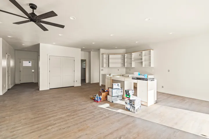 Spacious interior with wood-finish flooring, recessed ceiling lighting, and a modern ceiling fan