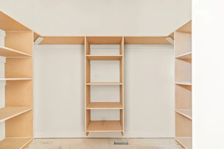 Built-in shelving system with vertical storage units and horizontal hanging rods