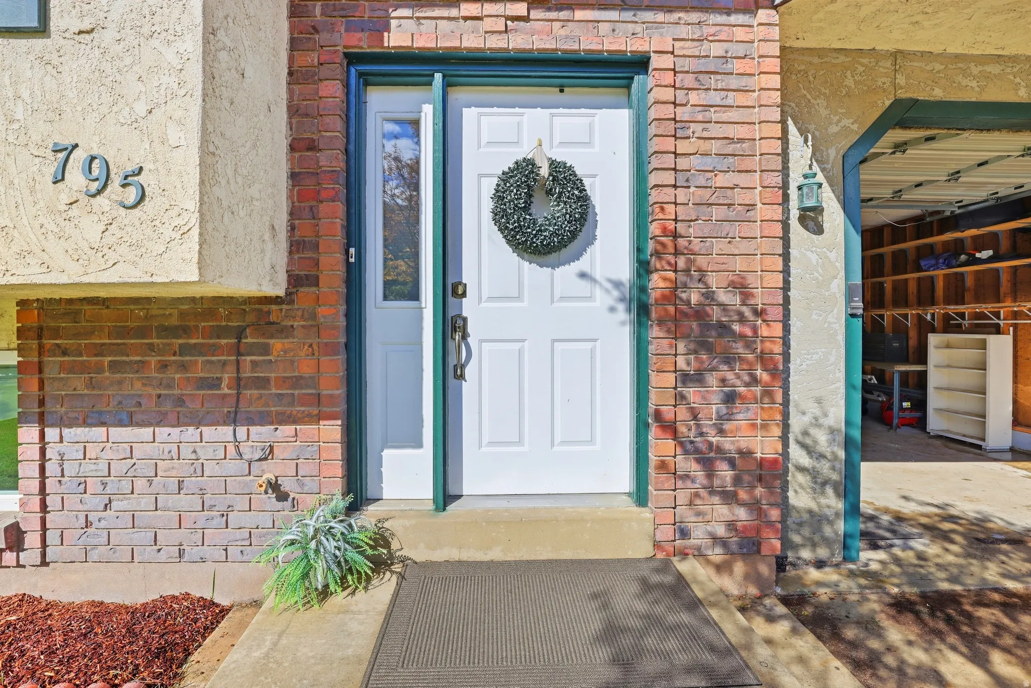 Brick and stucco exterior with a paneled front door featuring a sidelight