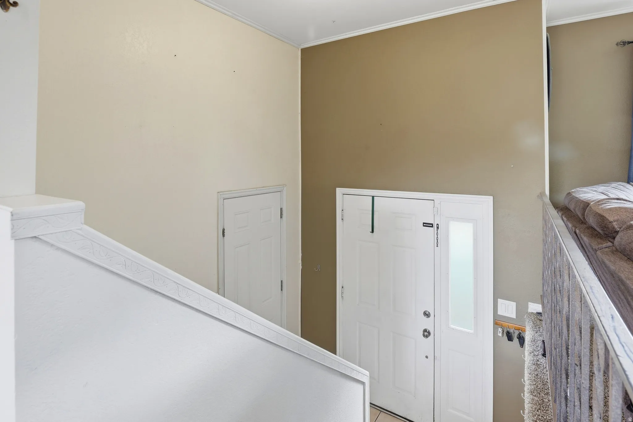 Entryway with a white paneled door, frosted glass sidelight, and an adjacent garage door