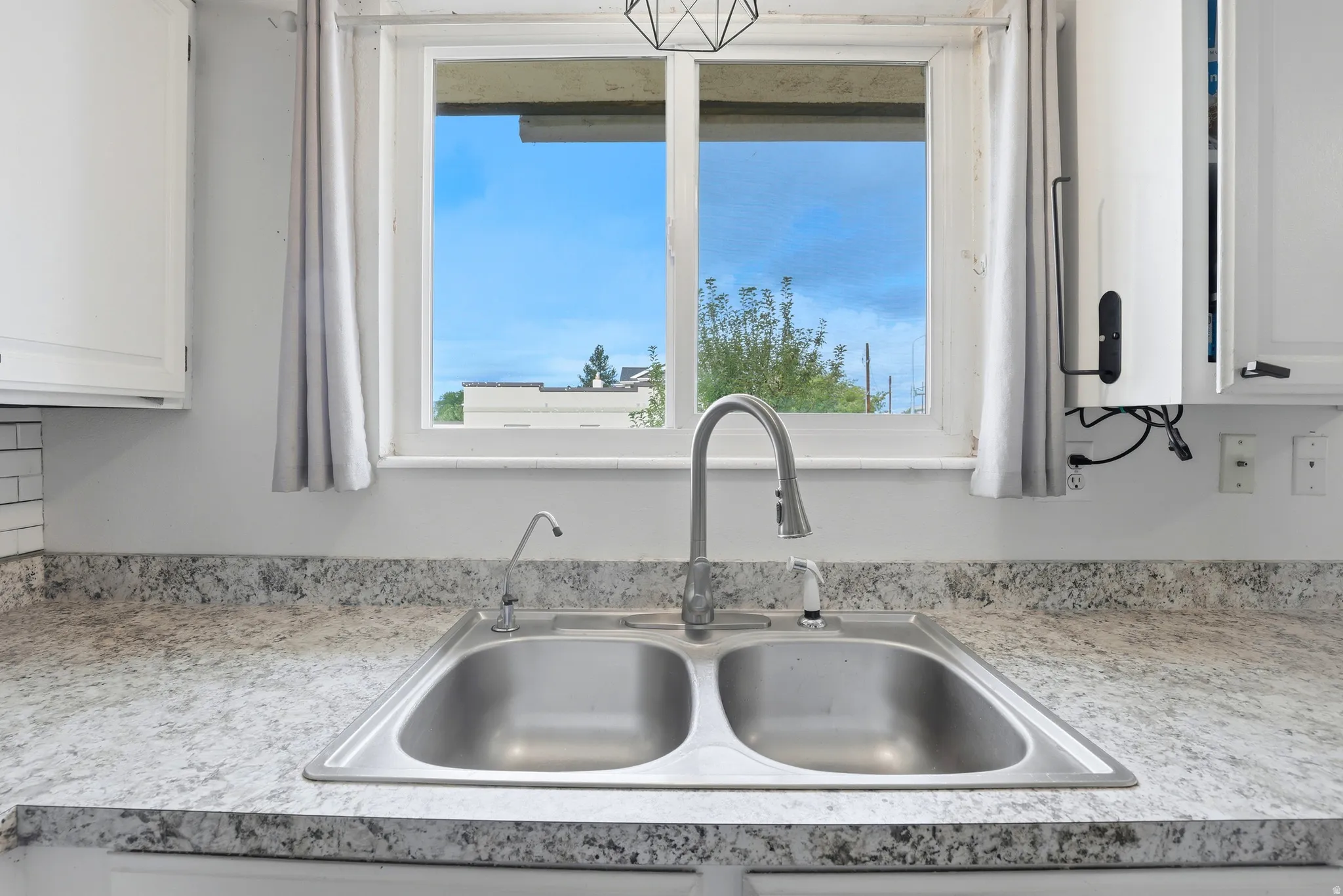 Dual basin stainless steel sink with a gooseneck faucet
