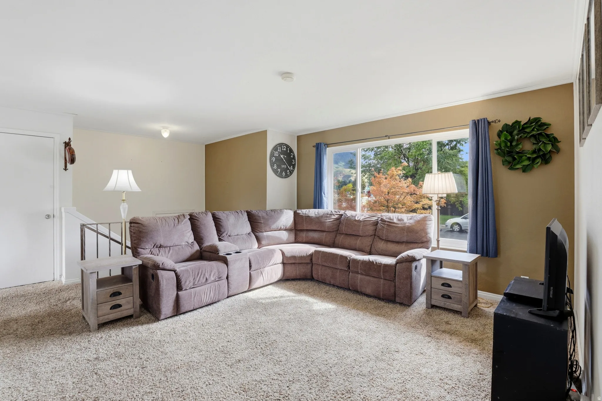 Light-colored carpeting throughout, with a large window providing ample natural illumination
