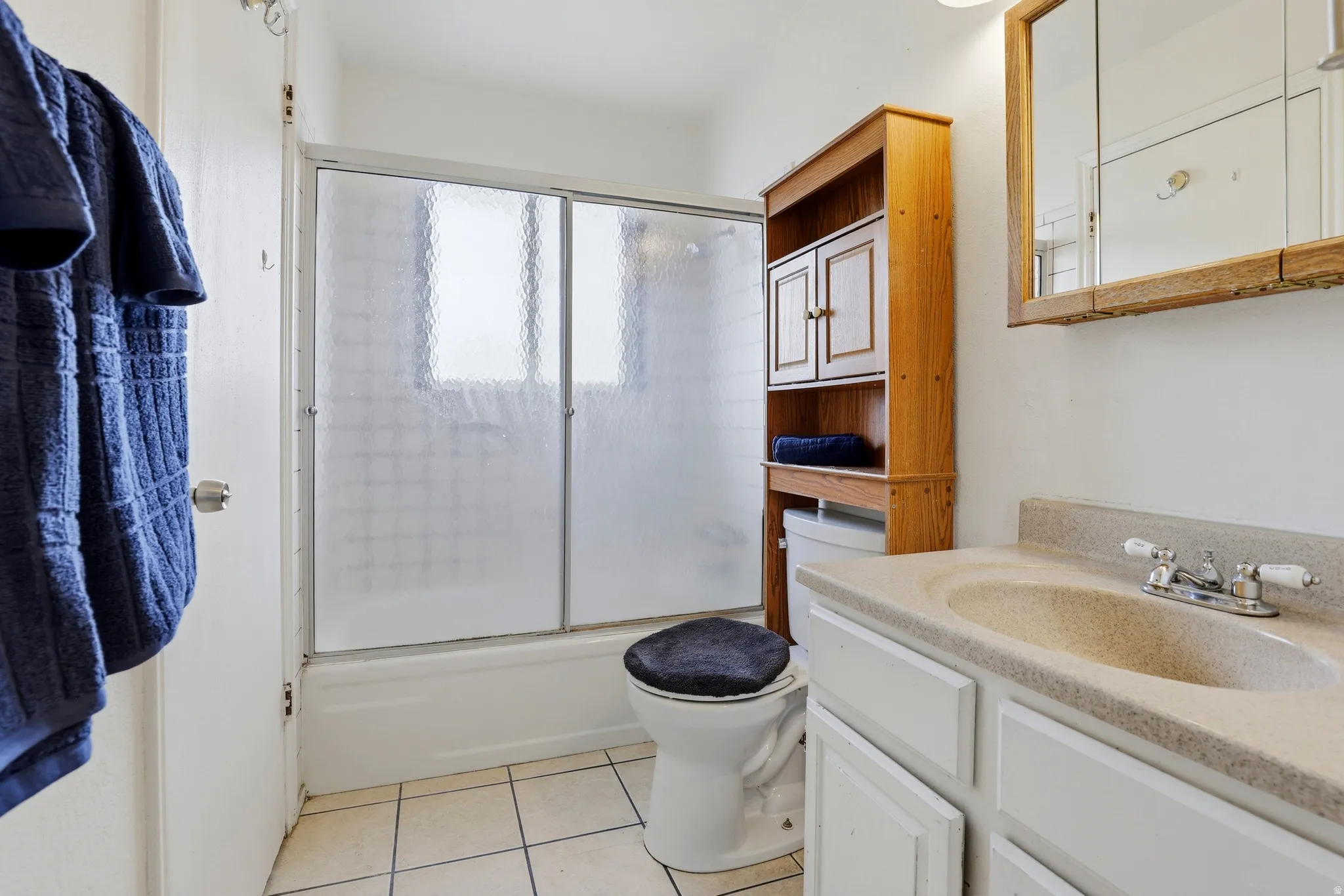 Bathroom with a shower-over-tub combination, tiled flooring, vanity with integrated sink, and an overhead medicine cabinet