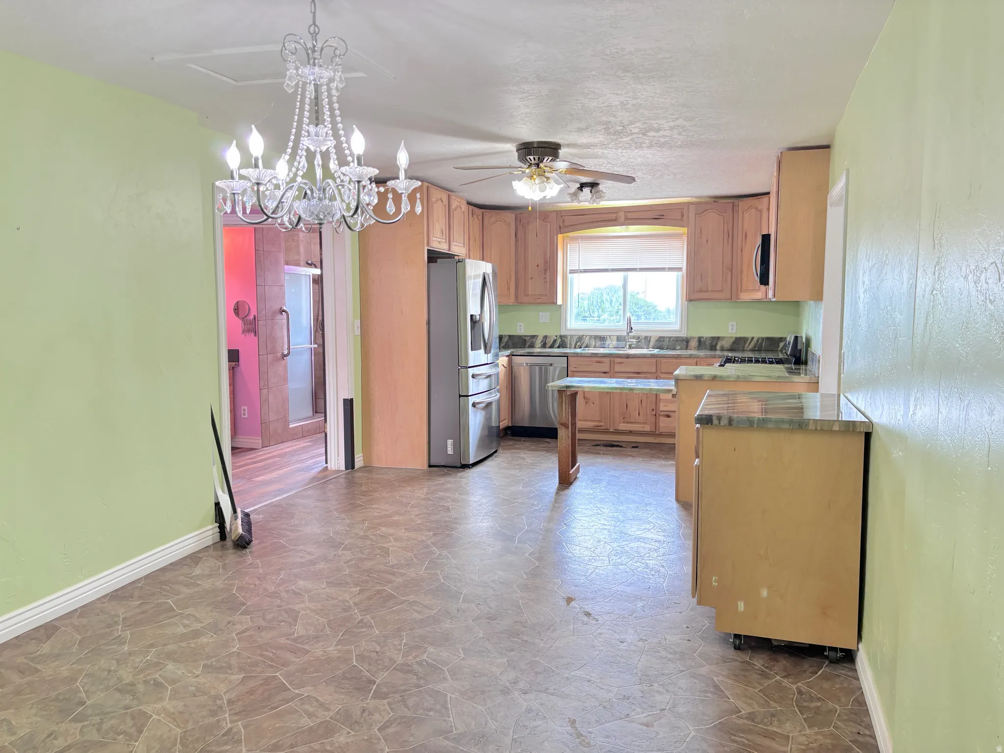 Kitchen featuring wood cabinetry, stainless steel appliances, and a ceiling fan