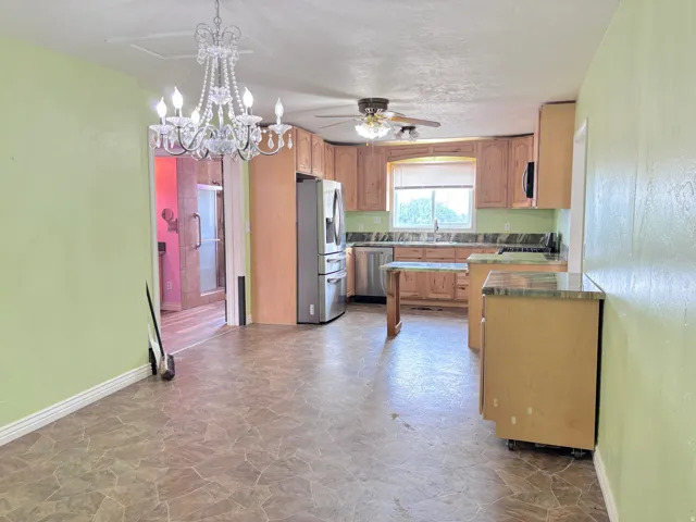 Kitchen featuring wood cabinetry, stainless steel appliances, and a ceiling fan