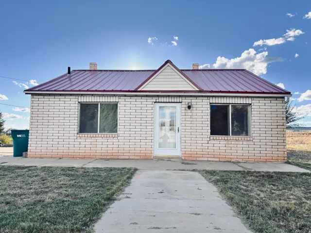 Light brick exterior with a red metal roof and a prominent central gable accent